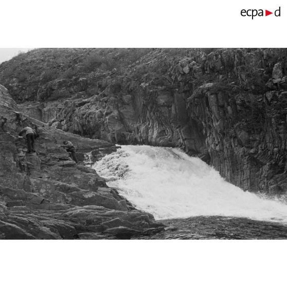 Des officiers de la Luftwaffe pèchent dans un cours d'eau montagneux en Finlande.