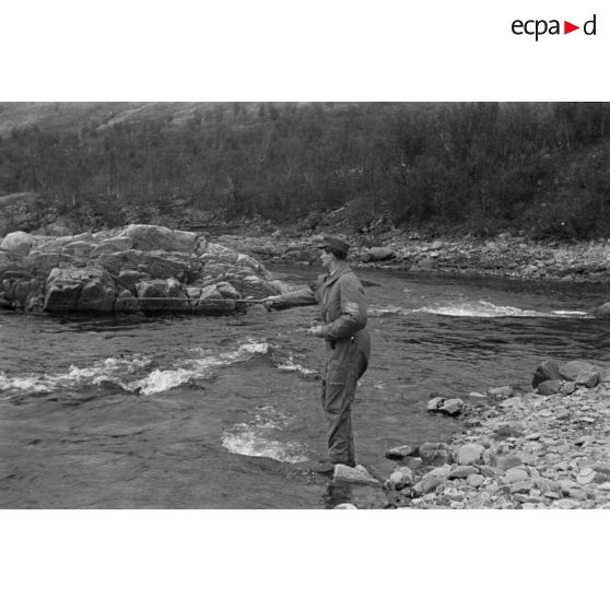 Des officiers de la Luftwaffe pèchent dans un cours d'eau montagneux en Finlande.