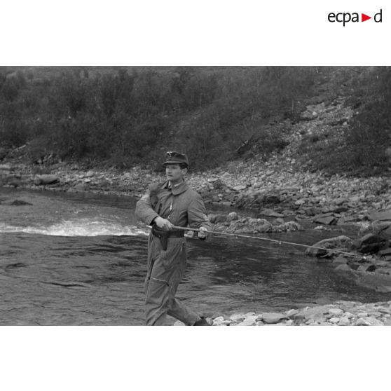 Des officiers de la Luftwaffe pèchent dans un cours d'eau montagneux en Finlande.