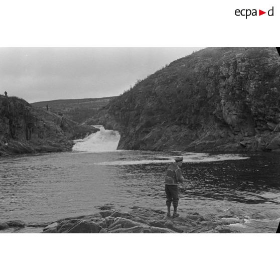Des officiers de la Luftwaffe pèchent dans un cours d'eau montagneux en Finlande.