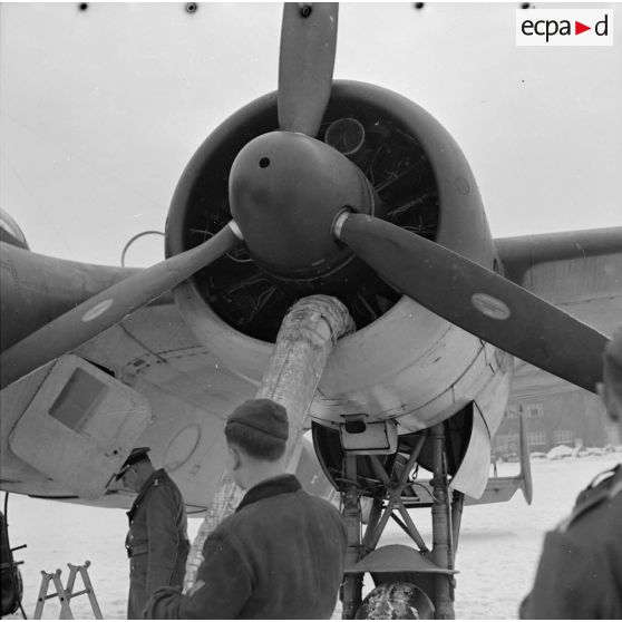 Préchauffage des moteurs d'un bombardier Dornier Do-17-P, à l'aide de gros tuyaux reliés à un canon à air chaud (générateur).