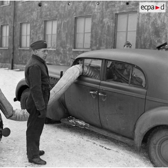 Préchauffage d'une automobile de type Horch-V8 à l'aide d'un tuyau relié à un canon à air chaud (générateur).
