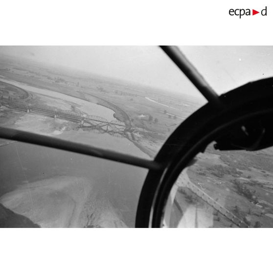 Au dessus de la Pologne, depuis la verrière nasale d'un bombardier Heinkel He-111, le survol d'un fleuve et d'un pont partiellement détruit.