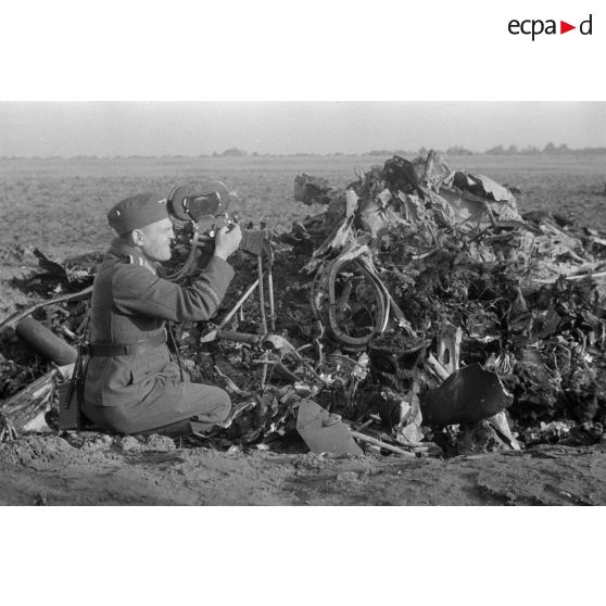 Un caméraman membre d'une compagnie de propagande de la Luftwaffe filme des débris provenant d'un avion abattu.