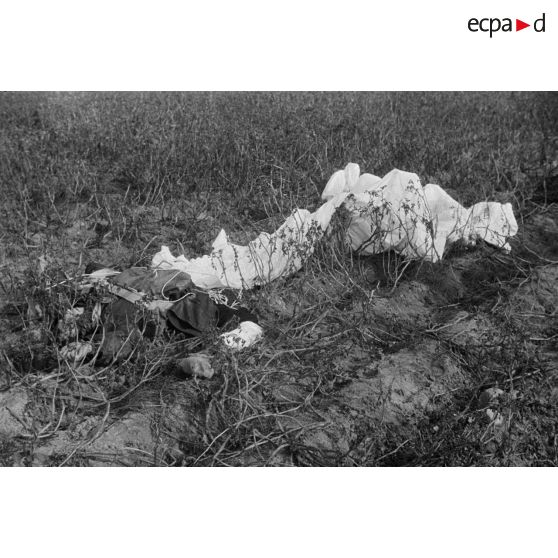 Cadavre d'un pilote soviétique, gisant sur le sol à côté de son parachute en torche.