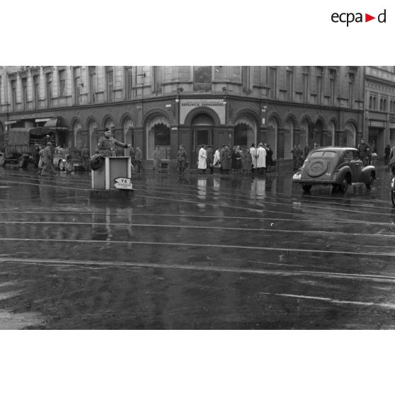 Dans une grande artère de Riga, un policier allemand règle la circulation.