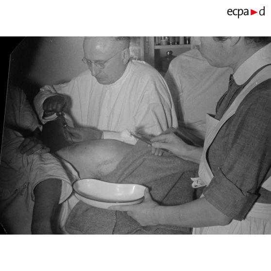 Un médecin fait une piqûre à un patient, assisté par une infirmière.