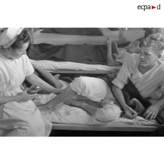 Une infirmière soigne la jambe d'un patient.