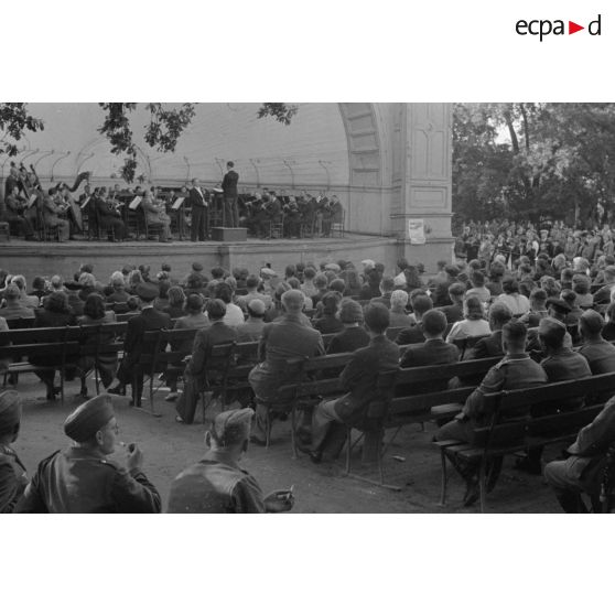 Un concert en plein air, dans le kiosque d'un parc, des aviateurs allemands assistent au spectacle.