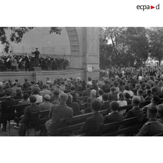Un concert en plein air, dans le kiosque d'un parc, des aviateurs allemands assistent au spectacle.