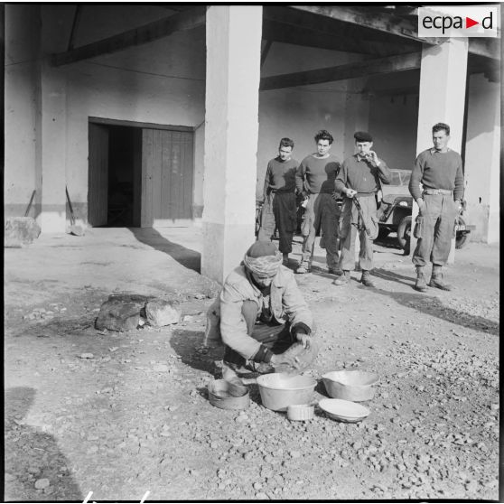 Corvée de plonge effectuée par un civil dans un cantonnement du 435e régiment d'artillerie Menerville.