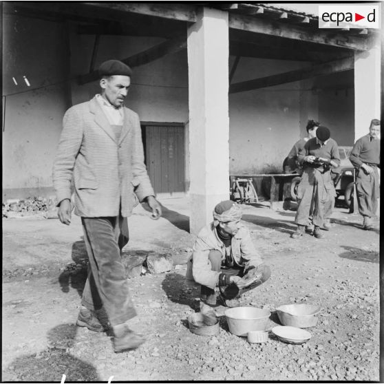 Corvée de plonge effectuée par un civil dans un cantonnement du 435e régiment d'artillerie Menerville.