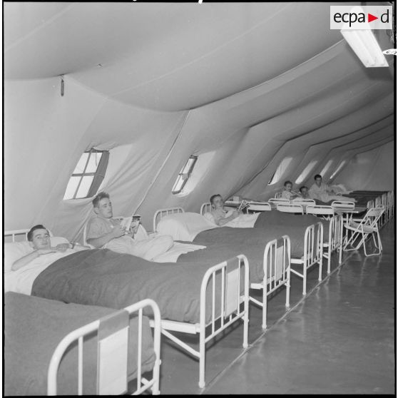 Centre médical de Maison-Blanche. Sous la tente, patients couchés dans leur lit.