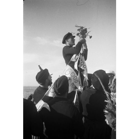 Lors du retour de la 8e mission en mer, l'équipage du sous-marin allemand U-Boot U-553 (commandé par Karl Thurmann) fixe les fanions sur lesquels sont indiqués le tonnage des bâtiments coulés.