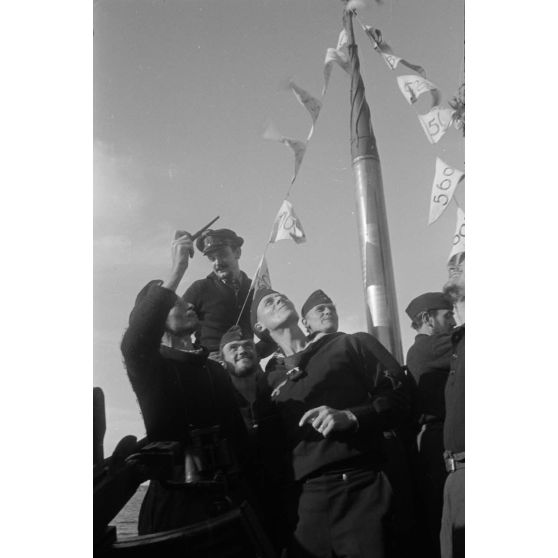 Lors du retour de la 8e mission en mer, l'équipage du sous-marin allemand U-Boot U-553 (commandé par Karl Thurmann) fixe les fanions sur lesquels sont indiqués le tonnage des bâtiments coulés.