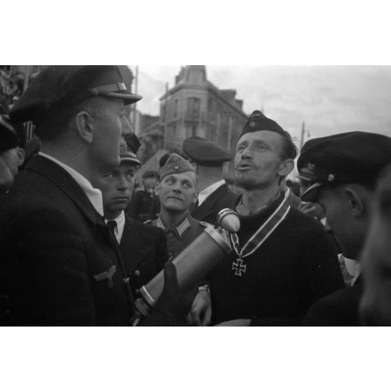 Le reporter (Rundfunkberichter) Heinrich Schwich réalise une interview du capitaine de corvette (Korvettenkapitän) Karl Thurmann, commandant du sous-marin U-553.