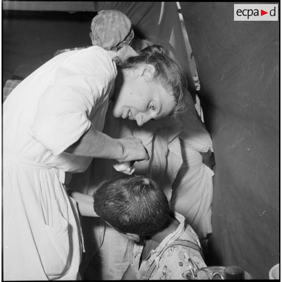 Medjajas. Une jeune infirmière soigne un enfant.