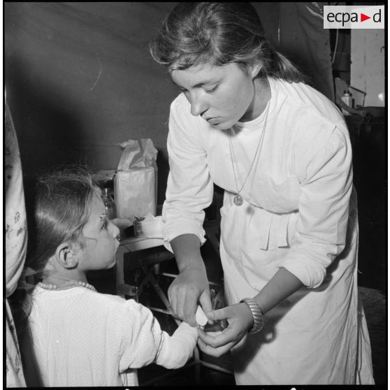 Medjajas. Une jeune infirmière soigne une fillette.