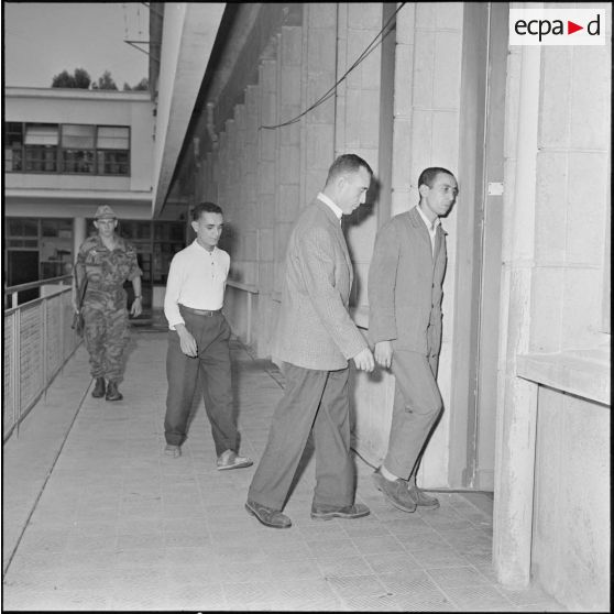 Les 3 chefs politiques du front de libération national (FLN) pénètrent dans la salle d'audience.