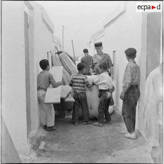 Des enfants s'installent dans leur logement de la cité "La Montagne" sous le regard d'un soldat.