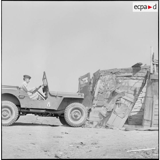 Destruction d'un gourbi à l'aide d'une jeep de l'action psychologique de Maison Carrée.
