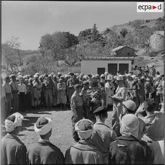 Le général Jacques Massu, commandant la 10ème division parachutiste (DP), décore un harki.