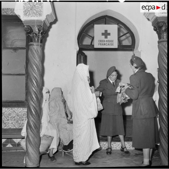 Madame Dupuis du comité d'Alger distribue du tissu et des bonbons.