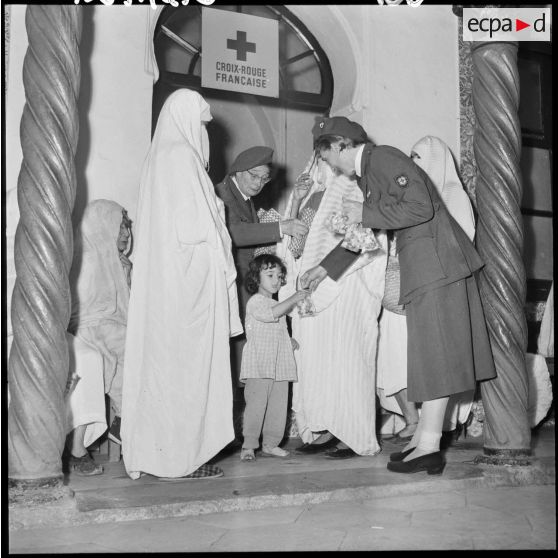 Madame Dupuis du comité d'Alger distribue du tissu et des bonbons.