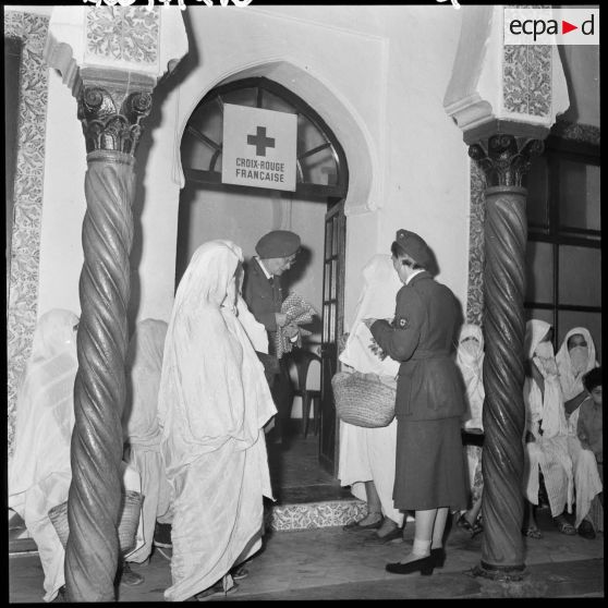 Madame Dupuis du comité d'Alger distribue du tissu et des bonbons.