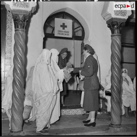 Madame Dupuis du comité d'Alger distribue du tissu et des bonbons.