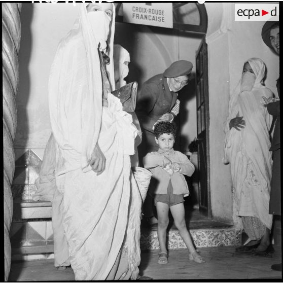 Madame Dupuis du comité d'Alger distribue du tissu et des bonbons.