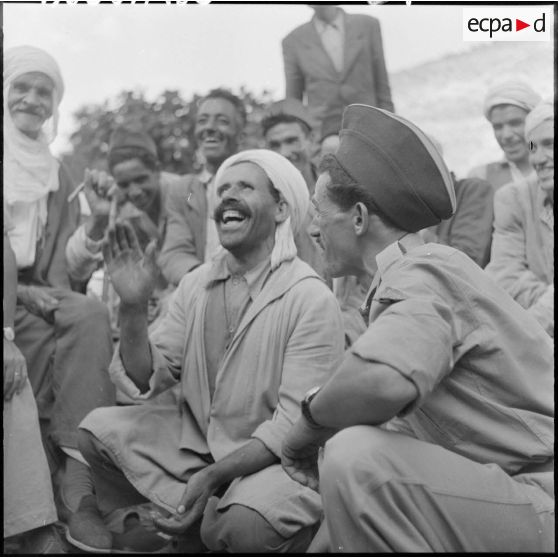 Deux parents, l'un garde du 3ème groupe mobile de protection rurale (GMPR) et l'autre paysan, se racontent les derniers potins du village.