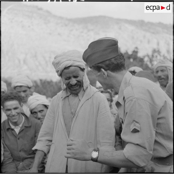 Deux parents, l'un garde du 3ème groupe mobile de protection rurale (GMPR) et l'autre paysan, se racontent les derniers potins du village.