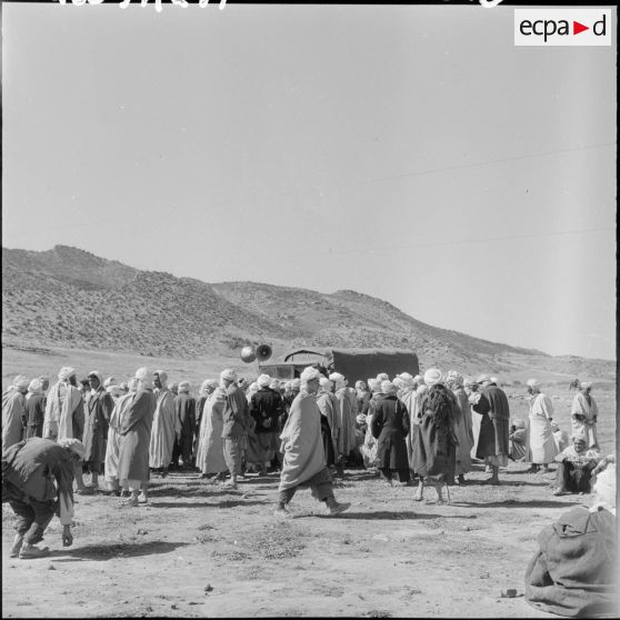 La foule entoure le camion haut-parleur.