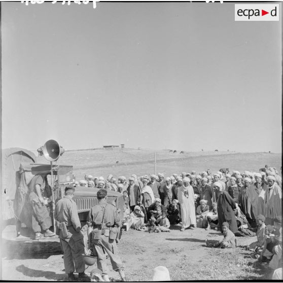 La foule entoure le camion haut-parleur.