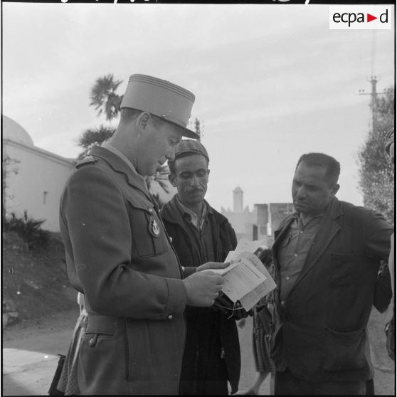 Le capitaine de la section administrative urbaine (SAU) de Bouzaréah renseigne des musulmans.