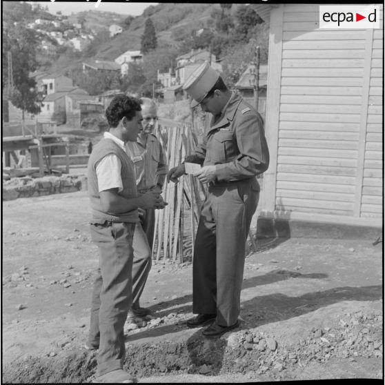 Le lieutenant de la section administrative urbaine (SAU) parle avec un chômeur.