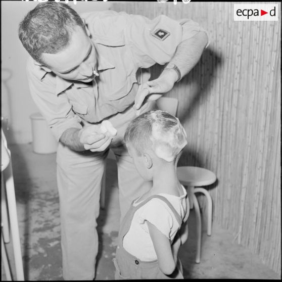 Infirmier soignant un jeune enfant.