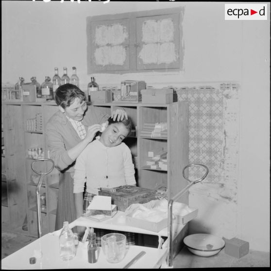 L'infirmière du dispensaire de Frais-Vallon soigne une fillette.