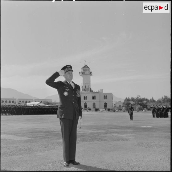 Le général Edmond Jouhaud, commandant la 5ème région aérienne, salue le drapeau de la base aérienne de Blida.