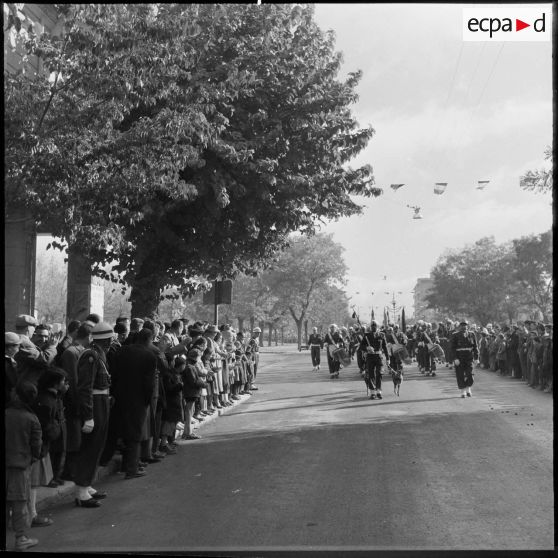 La foule et la musique du 3e régiment des tirailleurs algériens (RTA) au défilé du 11 novembre 1957 à Sétif.