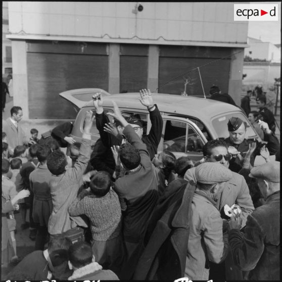 Un brigadier des CRS 41, distribue des chocolats et des bonbons à la population civile.