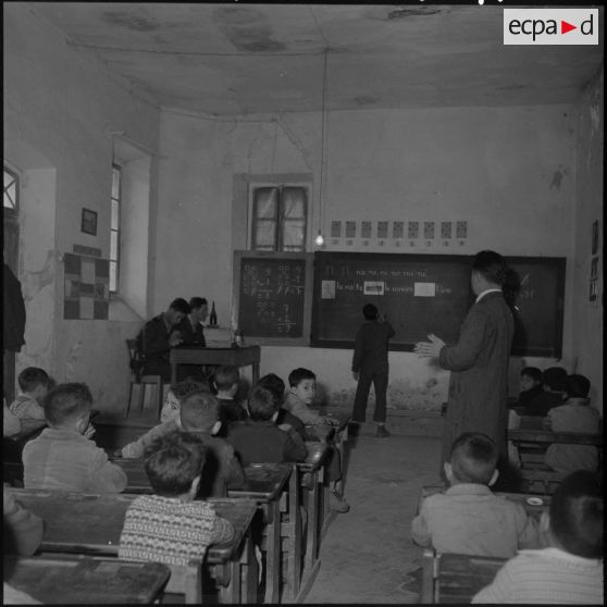Sous la conduite de l'instituteur de Bouïra deux stagiaires assistent aux cours.