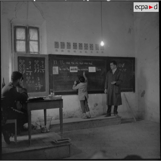 Sous la conduite de l'instituteur de Bouïra deux stagiaires assistent aux cours.