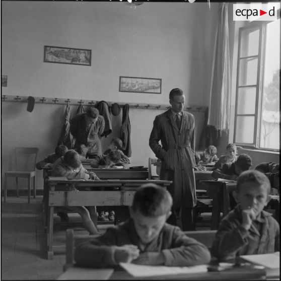 L'instituteur de Bouïra et un stagiaire militaire suivent les devoirs des enfants.