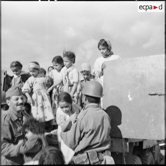 Les enfants grimpent dans le camion des soldats.