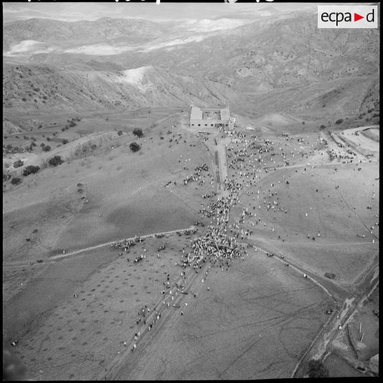 Vue aérienne de la foule entourant l'hélicoptère qui a amené le général Paul Gandoët sur les lieux de la cérémonie.
