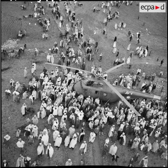 Vue aérienne de la foule entourant l'hélicoptère qui a amené le général Paul Gandoët sur les lieux de la cérémonie.