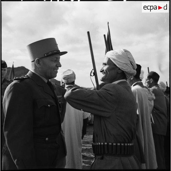 Le général Paul Gandoët passe en revue un détachement de la 1ère compagnie du 29ème bataillon de chasseurs à pied (BCP) et une harka.