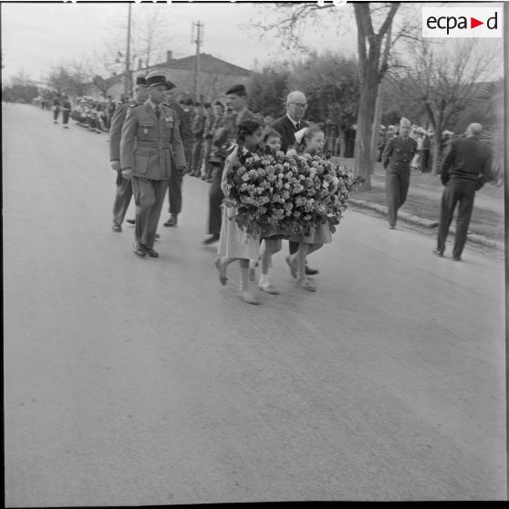 Monsieur Choiral accompagne trois petites filles qui portent une gerbe de fleurs.